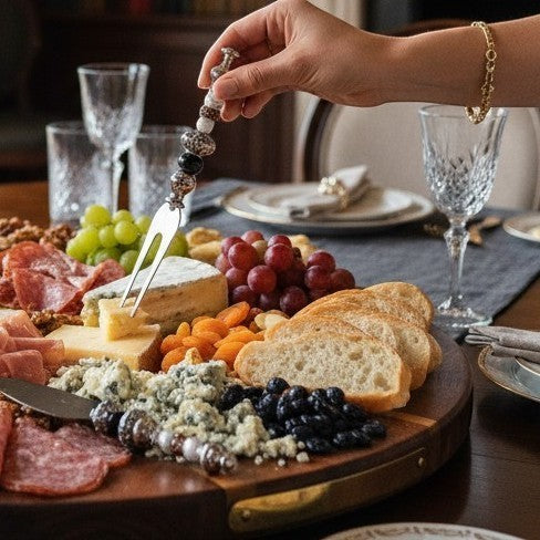 House of Lux Gifts handcrafted charcuterie fork with beaded handle serving cheese on a wooden board at a dinner party