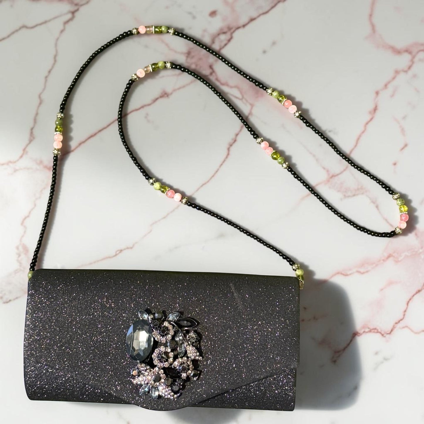 House of Lux Gifts black glitter evening clutch with crystal embellishment and a beaded shoulder strap.