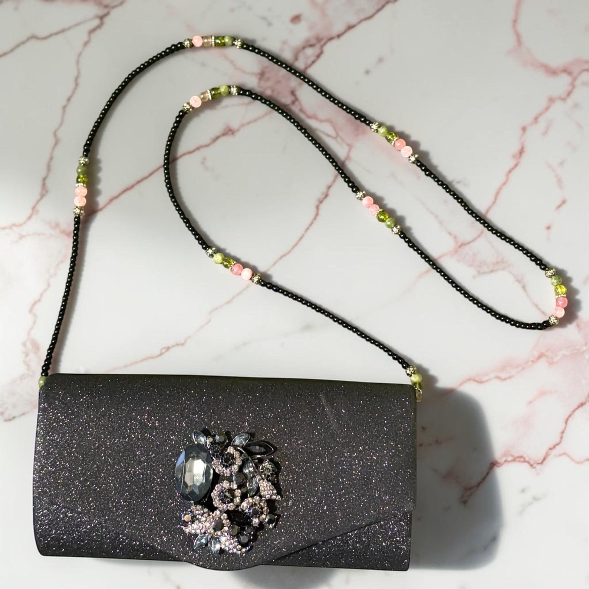 House of Lux Gifts black glitter evening clutch with crystal embellishment and a beaded shoulder strap.