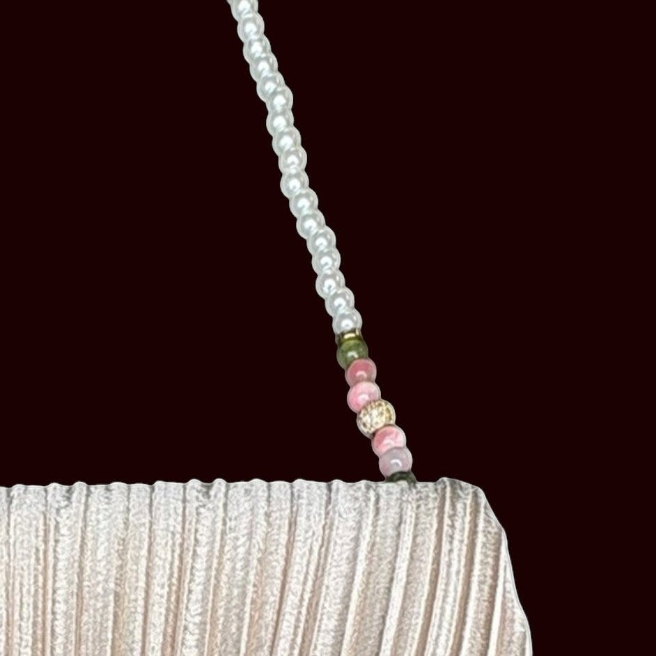 House of Lux Gifts cream pleated evening clutch with a beaded shoulder strap featuring pink quartz and green jade beads.