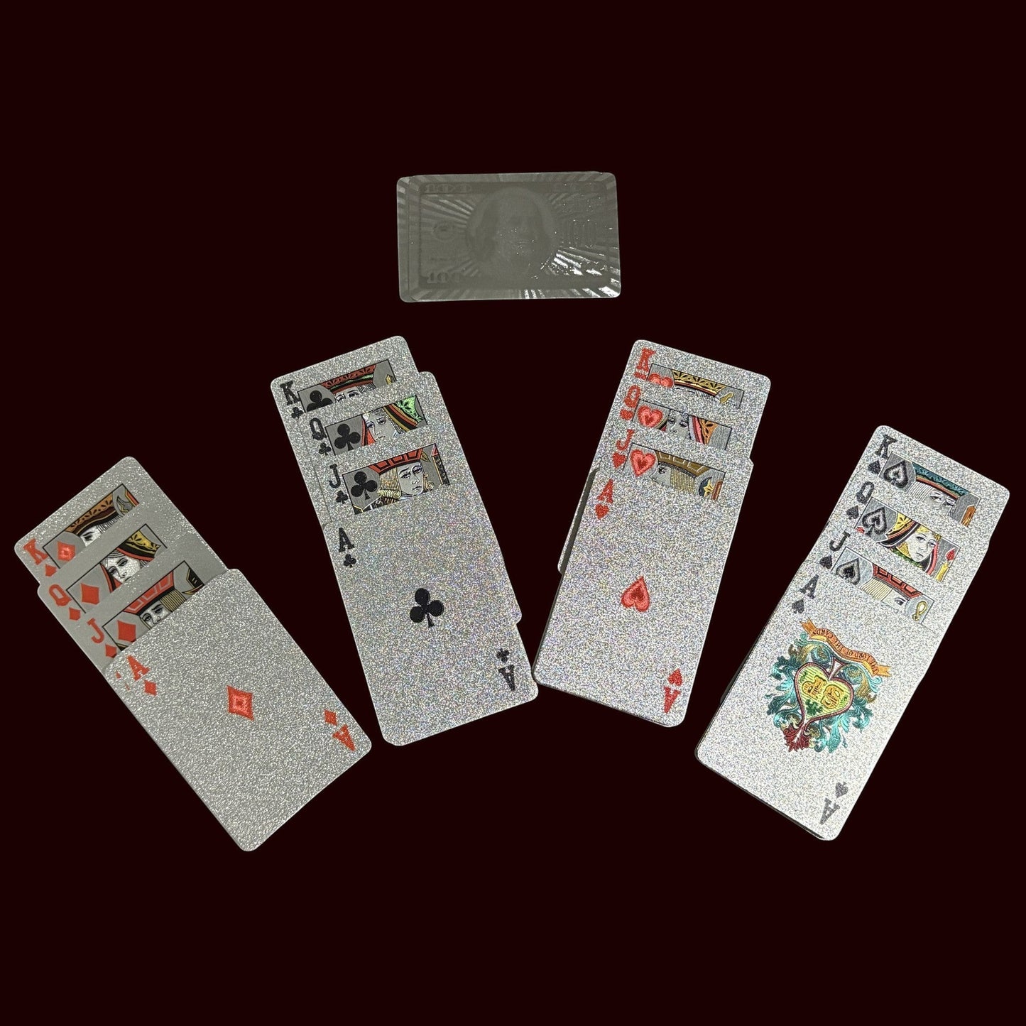 House of Lux Gifts silver glitter playing cards and a metallic hundred dollar bill token from a luxury game night set.