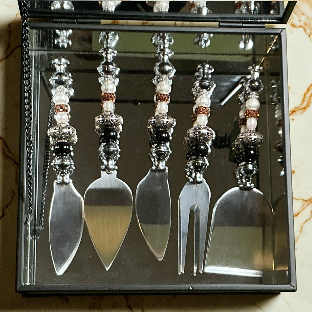House of Lux Gifts mirrored charcuterie gift box with five stainless steel serving tools featuring beaded handles.