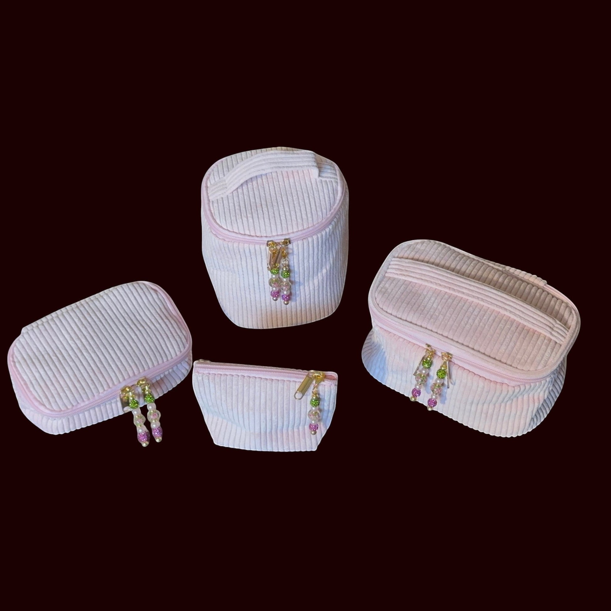 House of Lux Gifts 4-piece blush pink ribbed corduroy cosmetic bag set with gold zippers and beaded pulls.