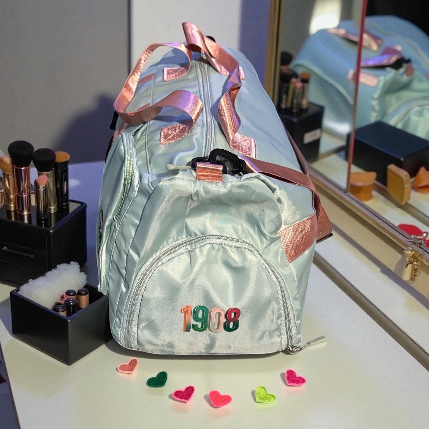 House of Lux Gifts pink and green duffel bag with 1908 embroidery, featuring side shoe compartment and suitcase straps.