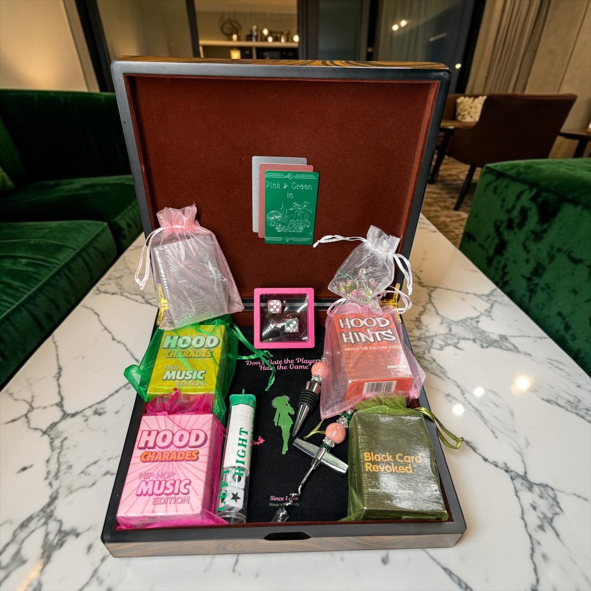 House of Lux Gifts pink and green luxury wooden game night box featuring card games, dice, and a wine stopper.