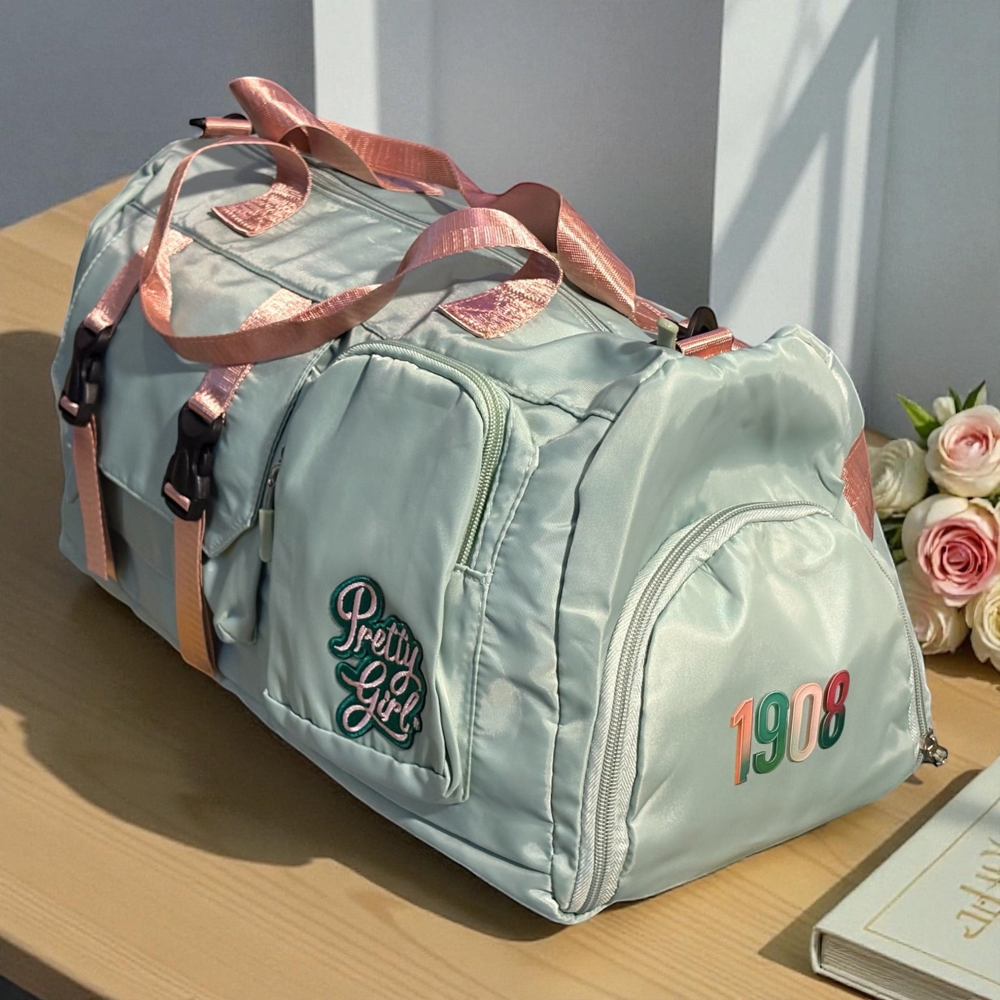 House of Lux Gifts pink and green Pretty Girl travel duffel bag with side shoe compartment and 1908 embroidery.