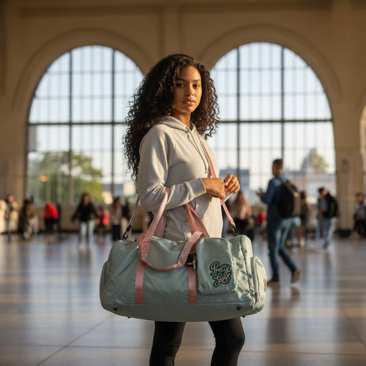House of Lux Gifts Pretty Girl travel duffel bag in green with pink straps, carried by a woman in a train station.