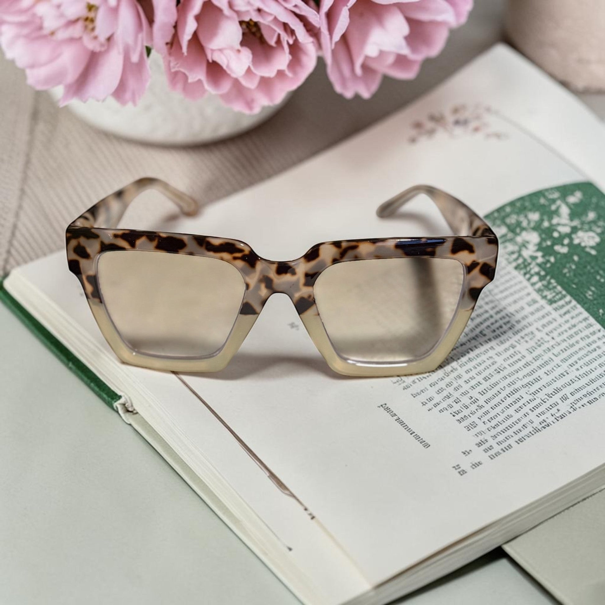 House of Lux Gifts geometric reading glasses with a tortoise shell pattern and blue light filtering lenses on a book.